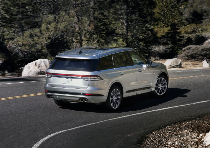 A 2023 Lincoln Aviator® Grand Touring model is shown being driven on a tight turn of a mountain road | Eau Claire Lincoln in Eau Claire WI