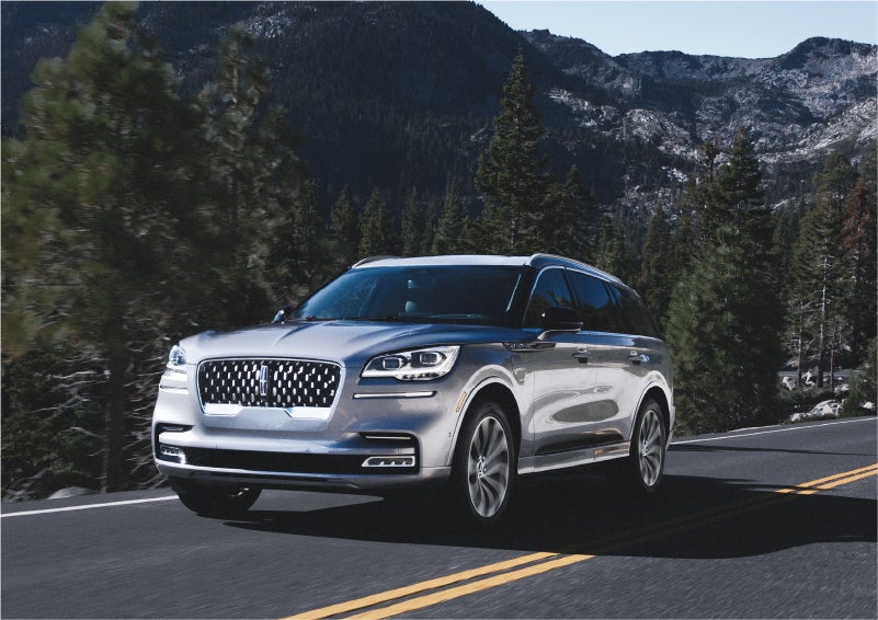A 2023 Lincoln Aviator® Grand Touring SUV being driven on a winding road to demonstrate the capabilities of all-wheel drive | Eau Claire Lincoln in Eau Claire WI