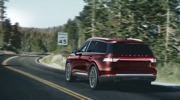 A 2024 Lincoln Aviator® SUV is being driven on a winding mountain road | Eau Claire Lincoln in Eau Claire WI
