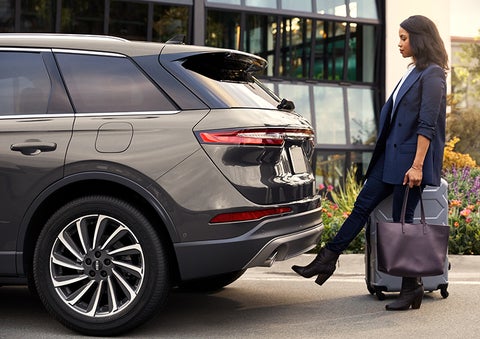 A woman with her hands full uses her foot to activate the available hands-free liftgate. | Eau Claire Lincoln in Eau Claire WI