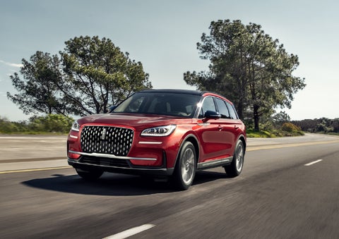A 2026 Lincoln Corsair® SUV is shown being driven on a country road. | Eau Claire Lincoln in Eau Claire WI