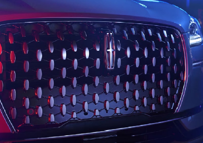 The grille of a 2025 Lincoln Corsair&reg; SUV reflects neon light at night. | Eau Claire Lincoln in Eau Claire WI