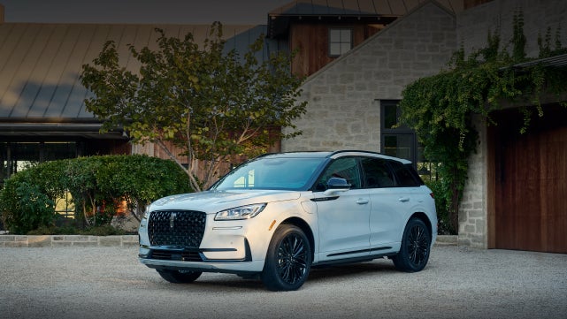 A 2026 Lincoln Corsair® SUV is parked in front off a luxury home. | Eau Claire Lincoln in Eau Claire WI