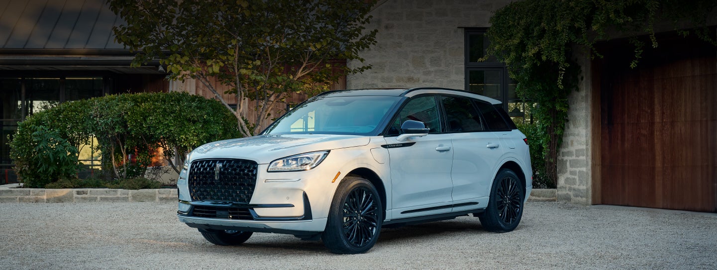 A 2026 Lincoln Corsair® SUV is parked in front off a luxury home. | Eau Claire Lincoln in Eau Claire WI