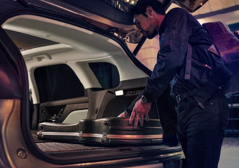 A man is shown loading cargo into the rear of a 2026 Lincoln Corsair® SUV with the second-row seats folded flat. | Eau Claire Lincoln in Eau Claire WI