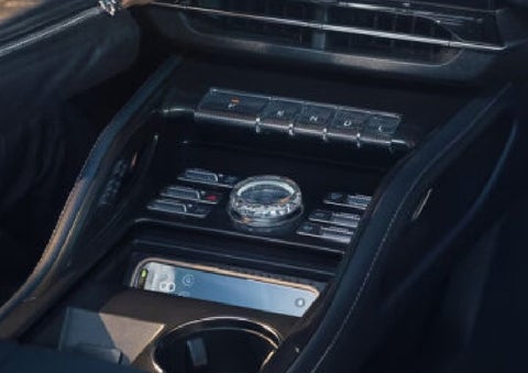 A smartphone is shown charging in the wireless charging pad. | Eau Claire Lincoln in Eau Claire WI